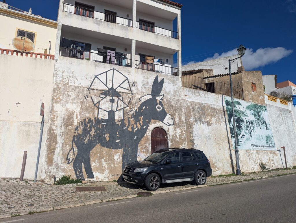 Streetart muurschildering op witgekalkte muur in centrum Alte